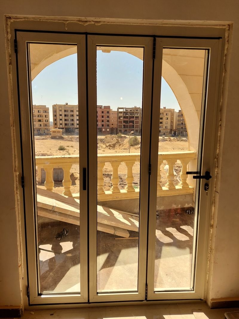 باب ألومنيوم قابل للطي بثلاث ضلف يطل على شرفة مقوسة