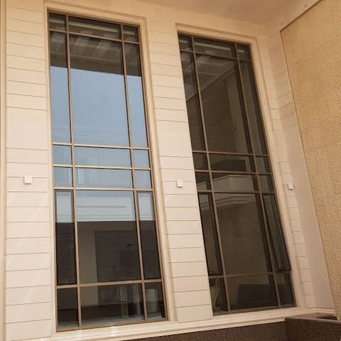 نوافذ ألومنيوم طويلة على واجهة حجرية